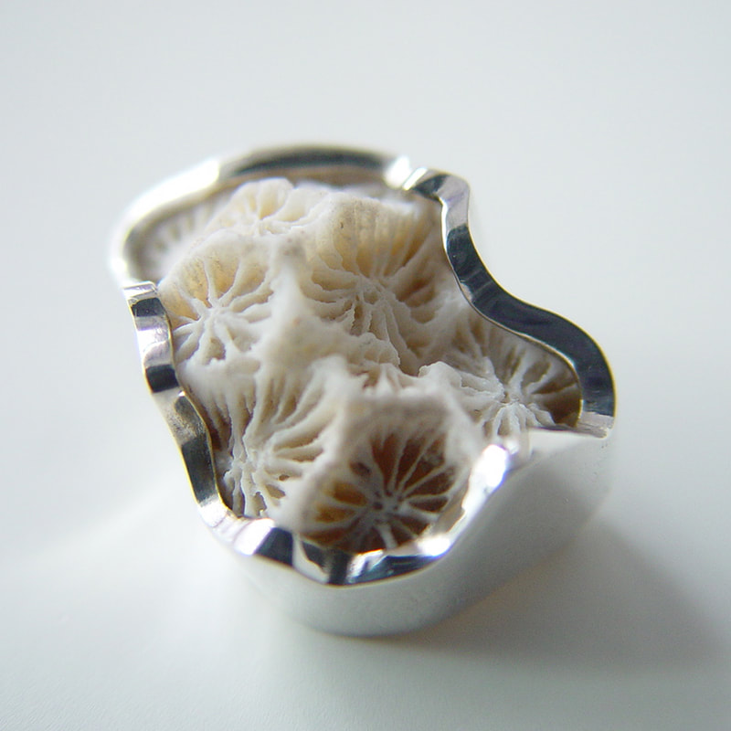 Titanic brooch irregular shape sterling silver rim around a white coral fossil representing the iceberg that destroyed the Titanic € 760,- Daphne Meesters Jewellery Designer Goldsmith The Hague Netherlands