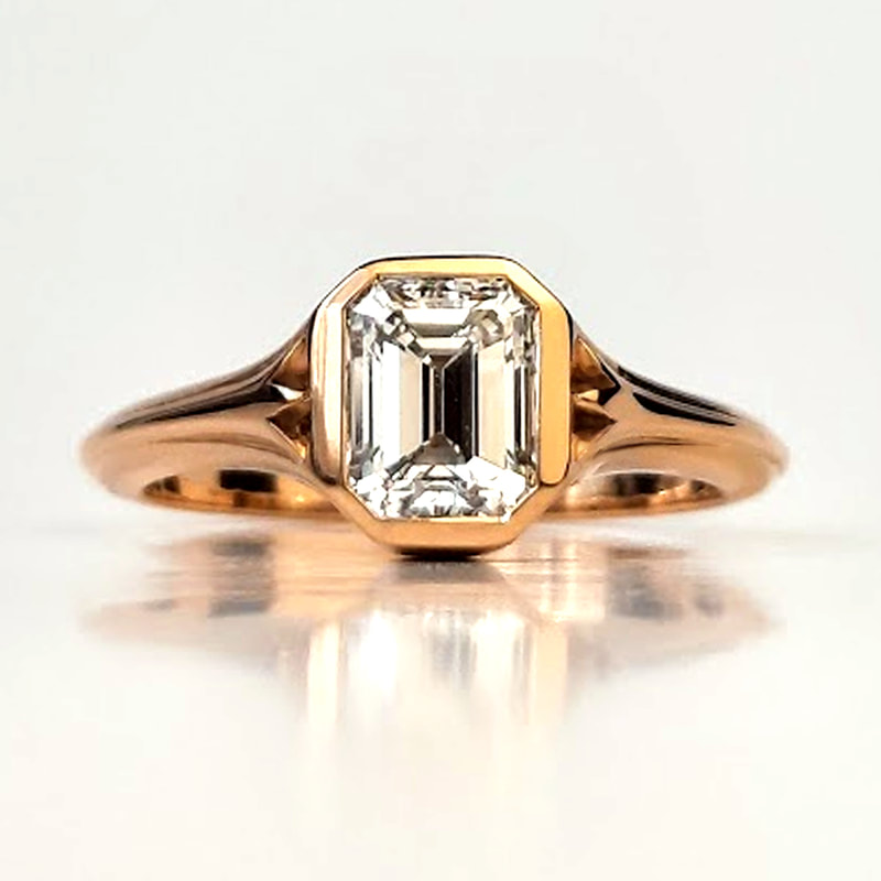 Flowers engagement ring signetring in 18K yellow gold with a stunning 0.93 ct. diamond in emerald cut and two abstract flowers on the sides Daphne Meesters Jewellery Designer Goldsmith The Hague Netherlands