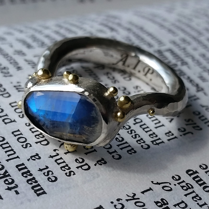 Full moon engagement ring dented hammered sterling silver shin rose cut irregular moonstone with blue hue little yellow gold balls from inherited pendant Daphne Meesters Jewellery  Designer Goldsmith The Hague Netherlands