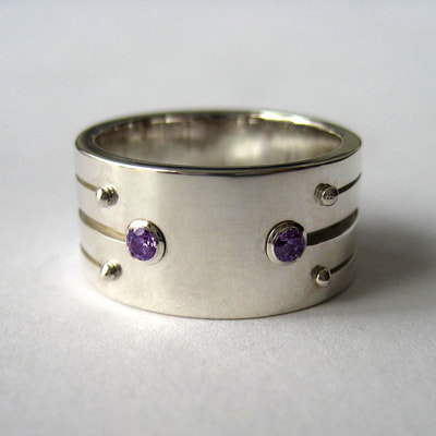 Engagement ring wide band with stripe pattern sterling silver and amethyst faceted stones Soyuz 1 love you to the moon and back say yes proposal Daphne Meesters Jewellery Designer Goldsmith The Hague Netherlands

