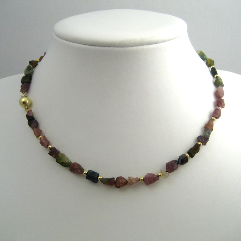 Falling leaves necklace 14K yellow gold beads and rough tourmaline green red orange pink  beads with 14K yellow gold lock Daphne Meesters Jewellery Designer Goldsmith The Hague Netherlands