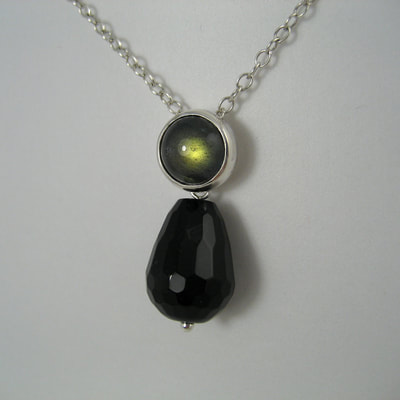 Pendant green labradorite cabochon with sterling silver bezel and faceted black onyx drop dangling Daphne Meesters Jewellery Designer Goldsmith The Hague Netherlands