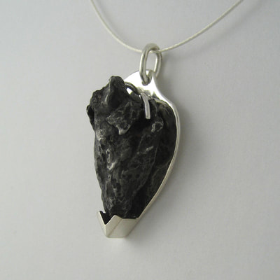 Meteorite pendant sterling silver and irregular shaped black meteorite love you to the moon and back Daphne Meesters Jewellery Designer Goldsmith The Hague Netherlands