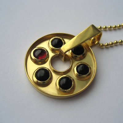 Russian roulette rotating pendant From Russia with love collection sterling silver 5 black onyx cabochons and 1 red garnet cabochon 14K gold layer 21 millimeters € 247,50 Daphne Meesters Jewellery Designer Goldsmith The Hague Netherlands