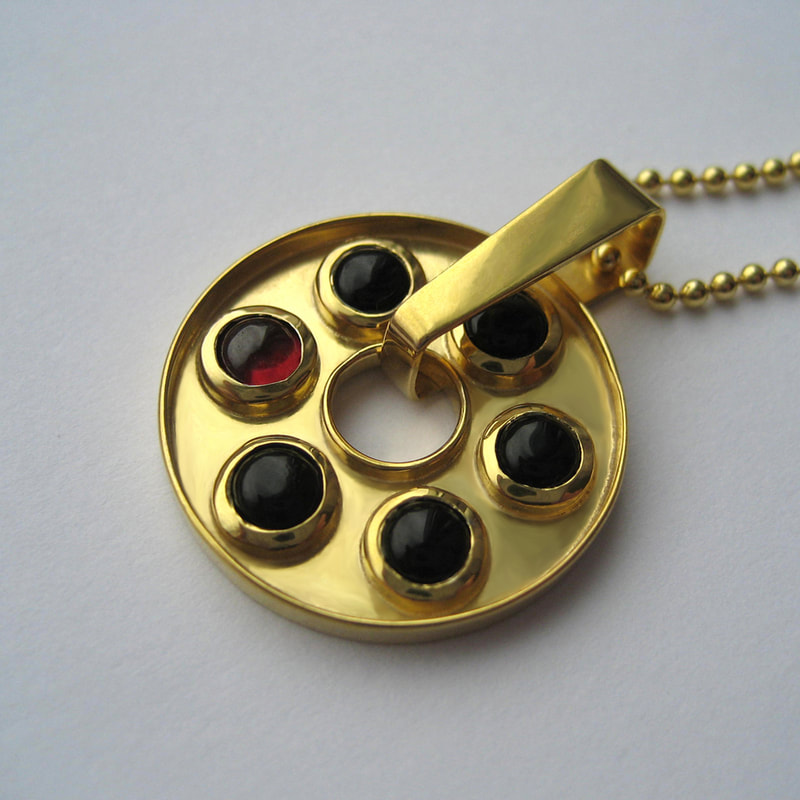 Russian roulette rotating pendant From Russia with love collection sterling silver 5 black onyx cabochons and 1 red garnet cabochon 14K gold layer 21 millimetres € 247,50 Daphne Meesters Jewellery Designer Goldsmith The Hague Netherlands