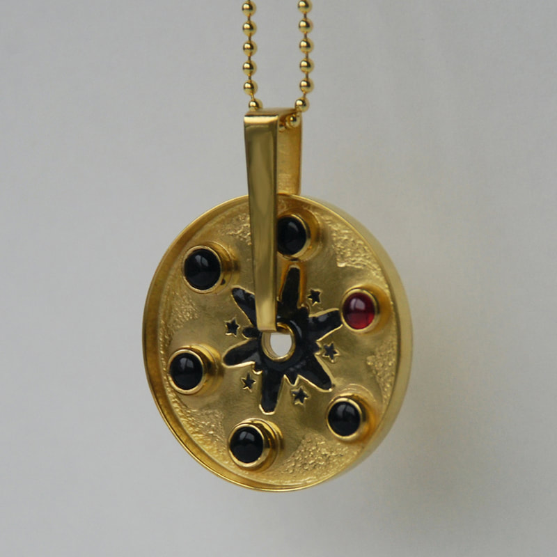 Russian roulette star rotating pendant From Russia with love collection sterling silver five black onyx cabochons and one red garnet cabochon with star pattern in black enamel 14K gold layer 29 millimetres € 412,50 Daphne Meesters Jewellery Designer Goldsmith The Hague Netherlands