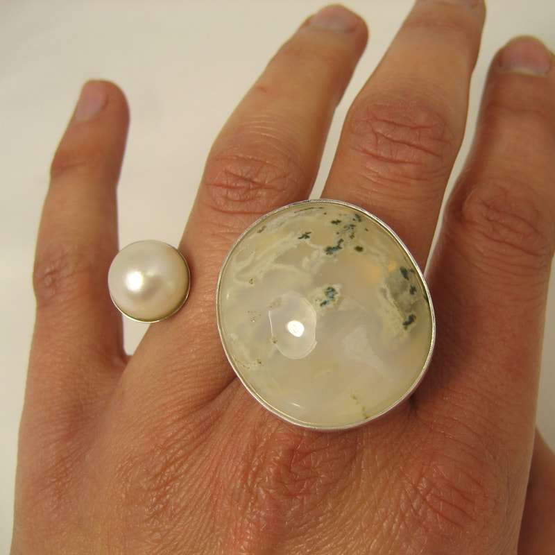 Snowglobe between fingers ring sterling silver huge cabochon moss agate and round white pearl size 16,5 millimeters € 415,-  Daphne Meesters Jewellery Designer Goldsmith The Hague Netherlands